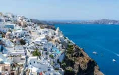 Casas blancas y cúpulas frente al mar en Santorini